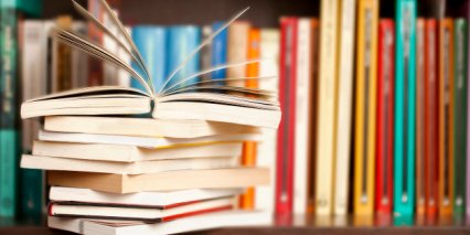 Stack of books on a shelf, multicolored book spines.